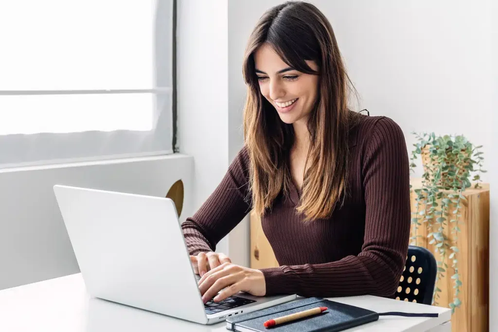 Smiling dietitian working on her laptop in a home office