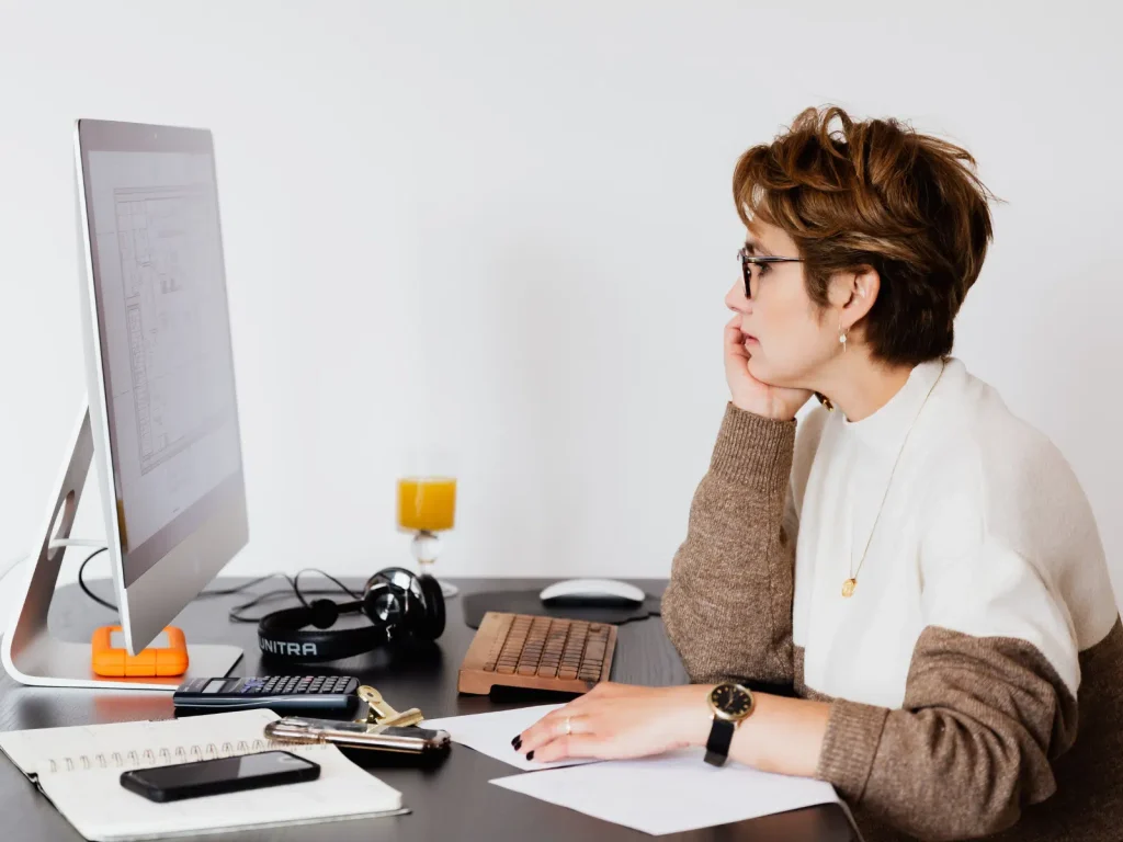 Wellness professional working at a desk with a computer and notebook while organizing content for repurposing