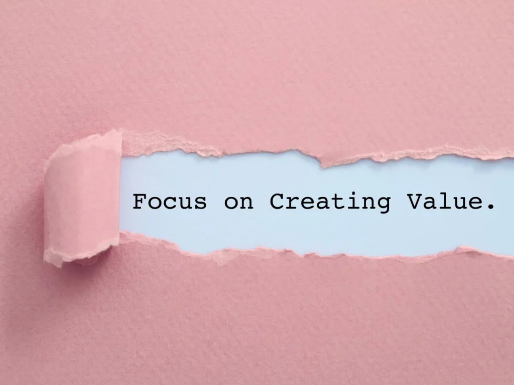 Torn pink paper revealing the words “Focus on Creating Value,” highlighting the mindset behind repurposing content
