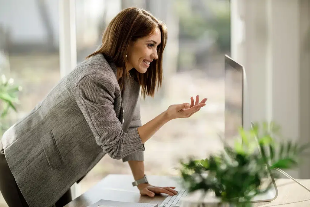 Woman smiling and leaning toward her computer, illustrating successful business models for future growth