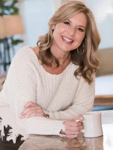 Lesli Bitel smiling while holding a coffee mug