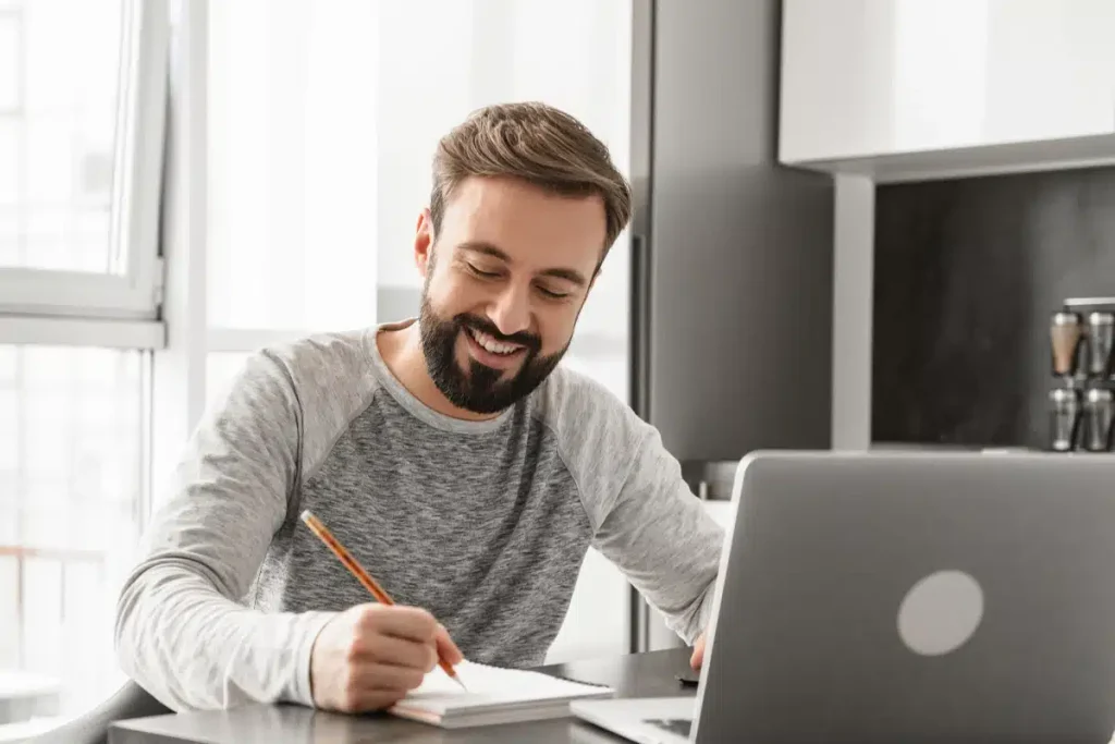 Man writing in a notebook with blog ideas, illustrating planning AI-generated content to match his personal style