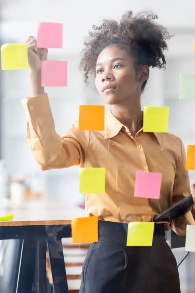 Woman writing on sticky notes during a private practice planning session