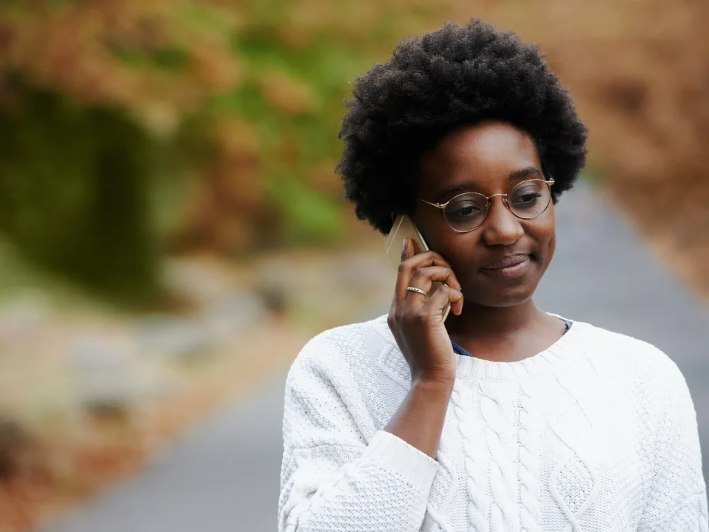 Practitioner talking on the phone outdoors, representing real client conversations that inspire authentic marketing content