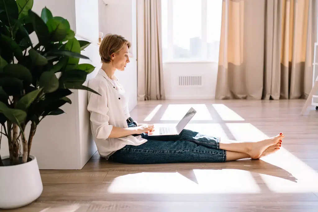 Woman sitting on the floor using her laptop to research video topics