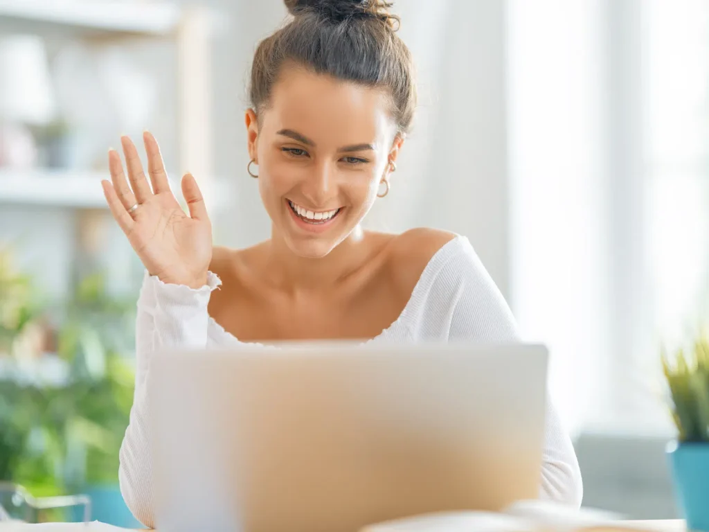 Smiling practitioner on a video call, demonstrating how virtual client conversations can be turned into marketing content