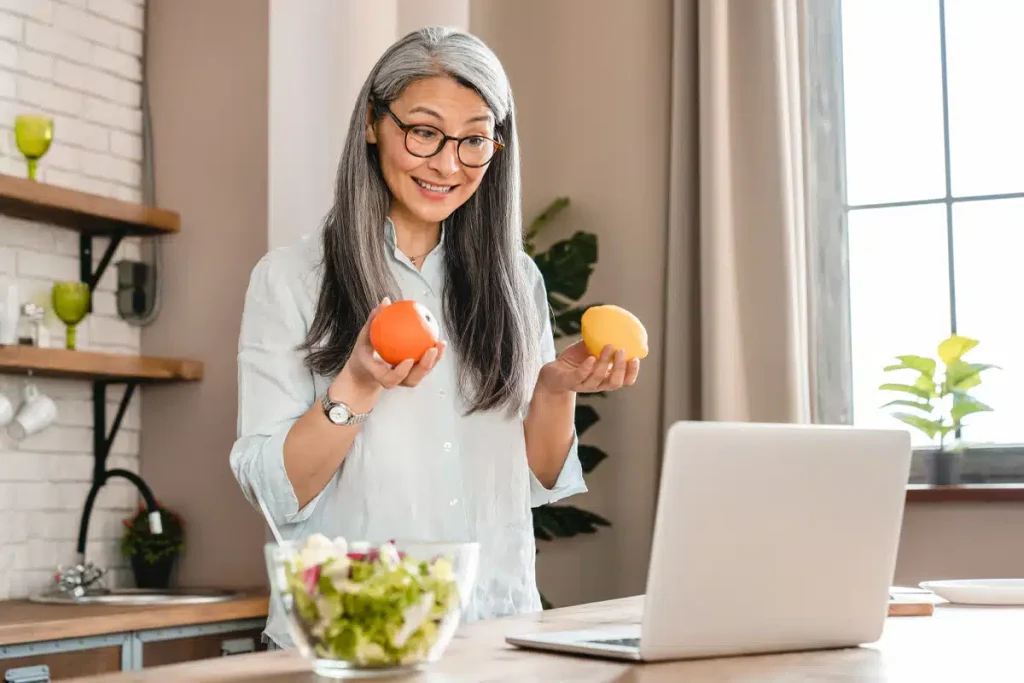 Dietitian on a video call holding fruits during a virtual consultation