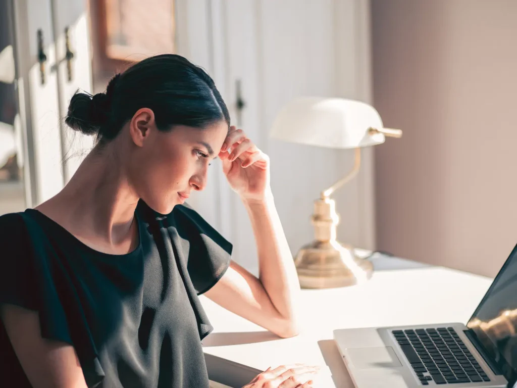 Woman working on a laptop while planning a sustainable approach to repurposing content