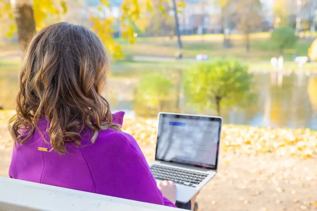 Woman working on her blog in the park, illustrating creating personalized content with ChatGPT